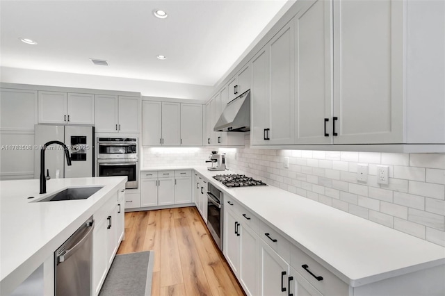 8608 Torrey Isles Ter, Boca Raton, FL 33496 - kitchen featuring under cabinet range hood, stainless steel appliances, light countertops, tasteful backsplash, and light wood-style flooring