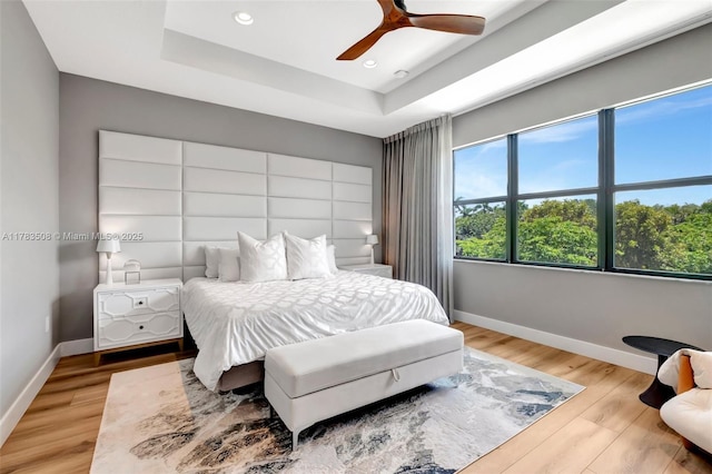 8608 Torrey Isles Ter, Boca Raton, FL 33496 - bedroom featuring light wood-style flooring, recessed lighting, a tray ceiling, and a ceiling fan
