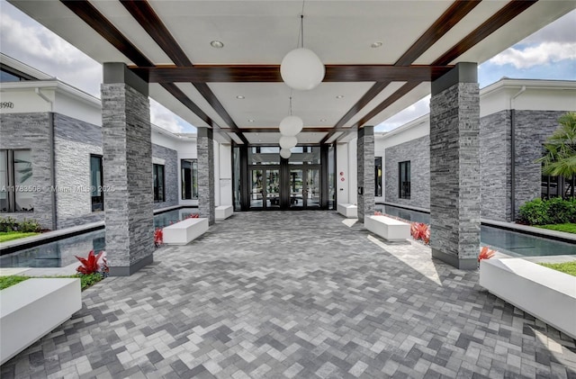 8608 Torrey Isles Ter, Boca Raton, FL 33496 - view of community with a fireplace, beamed ceiling, ornate columns, and french doors