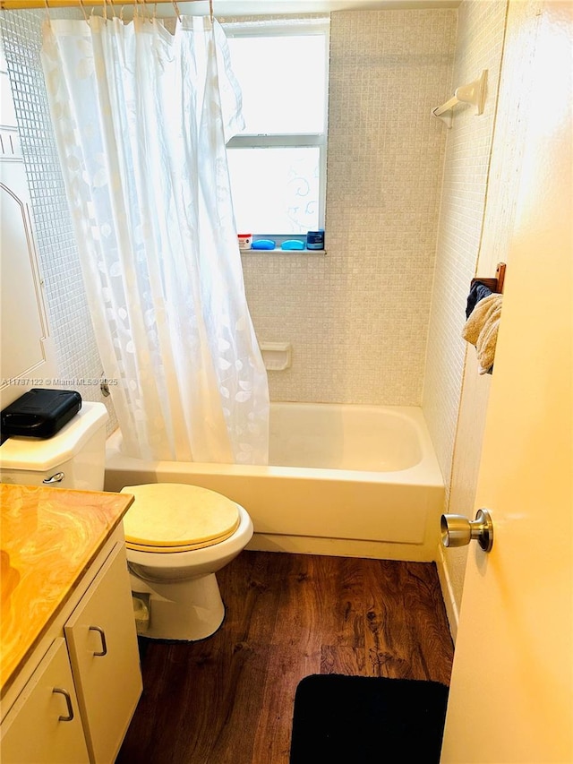 bathroom with wood finished floors, shower / bath combo with shower curtain, toilet, and vanity