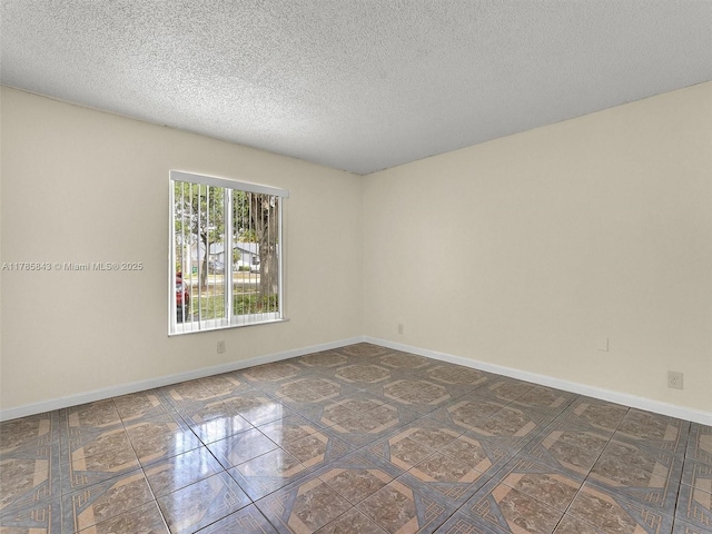 unfurnished room featuring baseboards and a textured ceiling