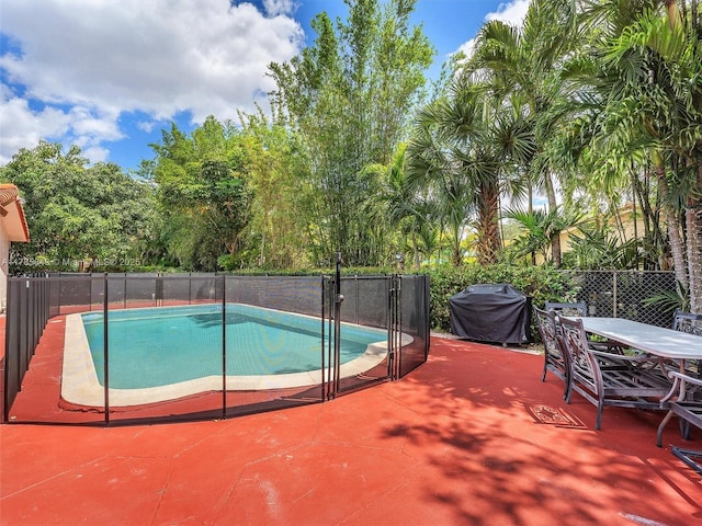 view of pool with a fenced in pool, fence, outdoor dining space, area for grilling, and a patio