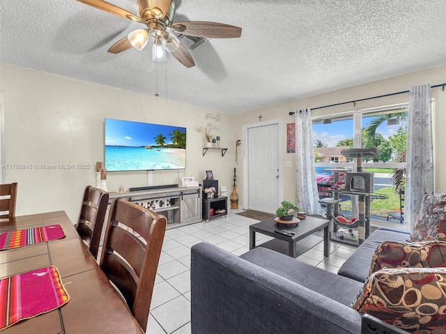 living room with ceiling fan, light tile patterned flooring, and a textured ceiling