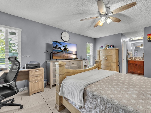 bedroom featuring a textured ceiling, a ceiling fan, a sink, and light tile patterned floors