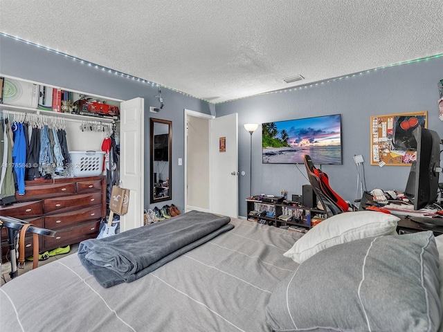bedroom with a textured ceiling and a closet