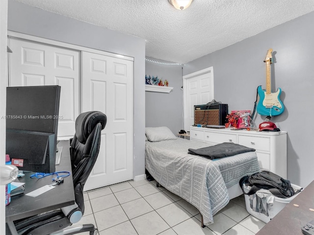 bedroom featuring light tile patterned flooring, a textured ceiling, and a closet