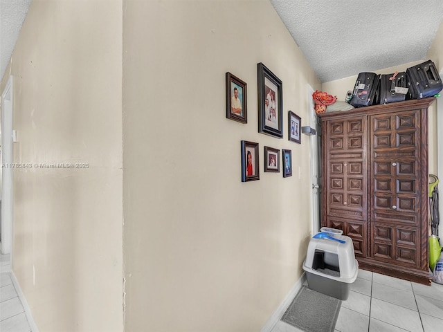 interior space featuring baseboards, tile patterned flooring, and a textured ceiling