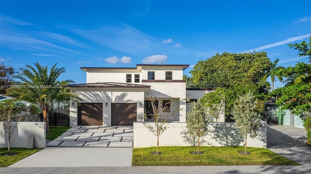 view of front facade with concrete driveway, fence, metal roof, stucco siding, and a standing seam roof