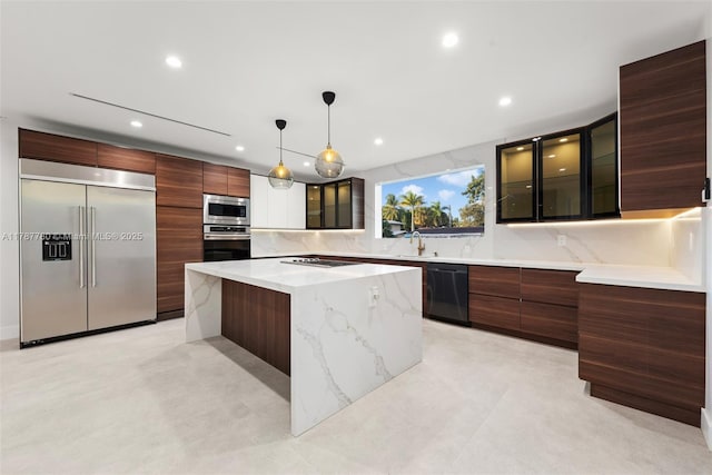 kitchen with recessed lighting, modern cabinets, a kitchen island, black appliances, and glass insert cabinets