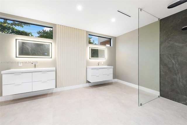 interior space featuring a wealth of natural light, visible vents, two vanities, and a walk in shower