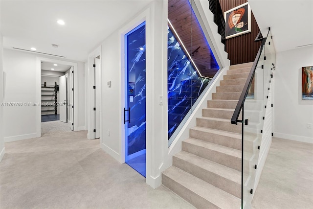 staircase featuring baseboards and recessed lighting