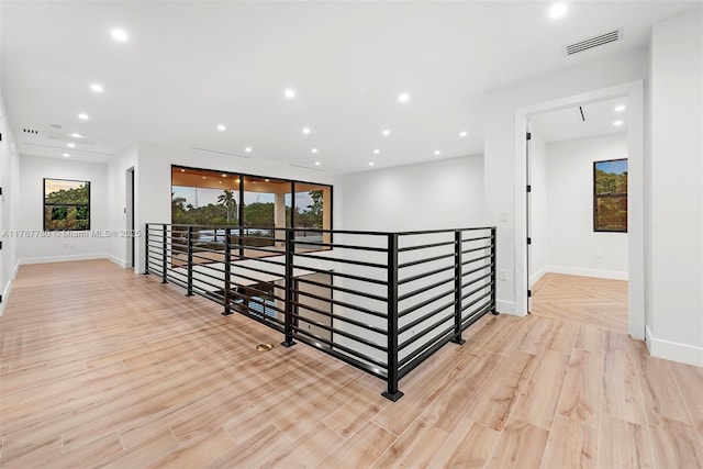 hall featuring plenty of natural light, visible vents, and an upstairs landing