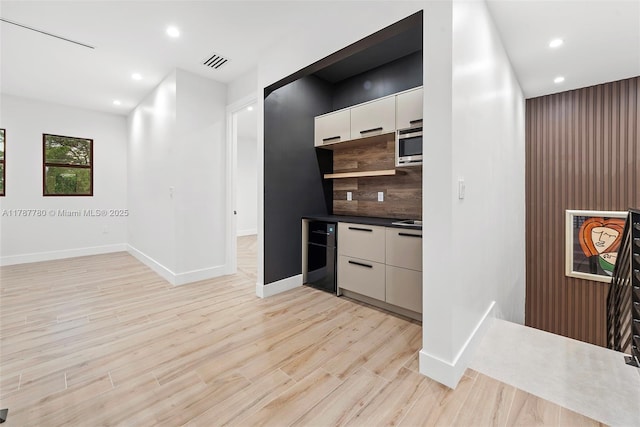 kitchen with visible vents, modern cabinets, baseboards, light wood-style flooring, and white cabinetry