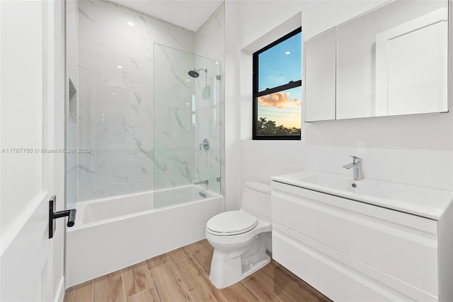 full bathroom featuring wood finished floors, vanity, washtub / shower combination, and toilet