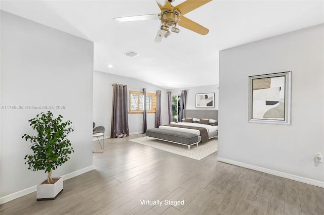 bedroom featuring lofted ceiling, baseboards, wood finished floors, and visible vents
