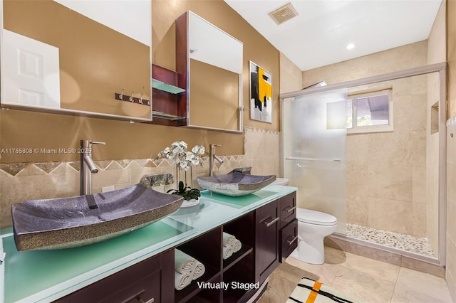 full bathroom with tile walls, visible vents, toilet, and a stall shower