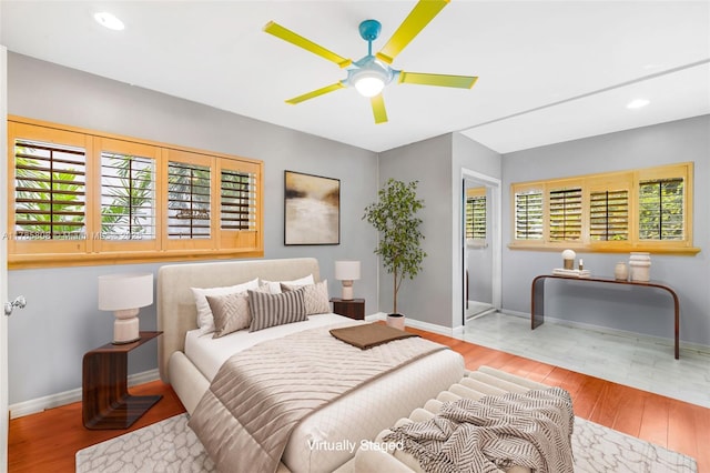 bedroom with baseboards, wood finished floors, recessed lighting, and ceiling fan