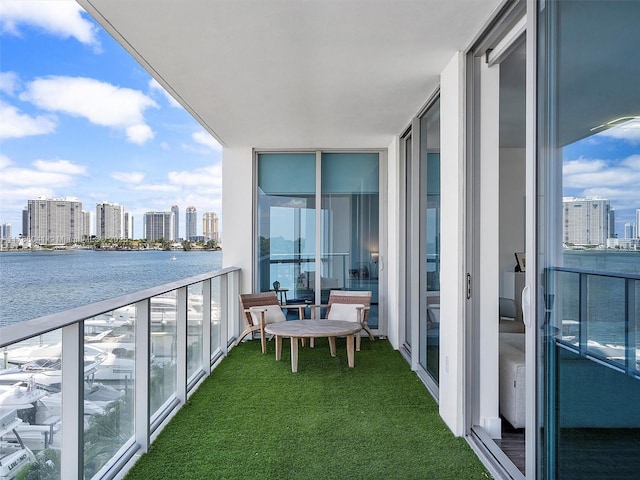 balcony with a water view and a view of city