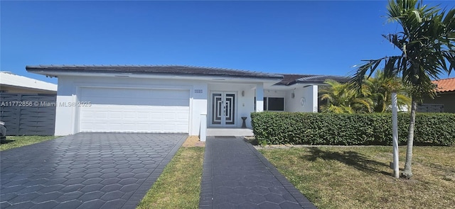 1531 SW 126th Pl, Miami, FL 33184 - view of front of property featuring an attached garage, a front lawn, stucco siding, and driveway