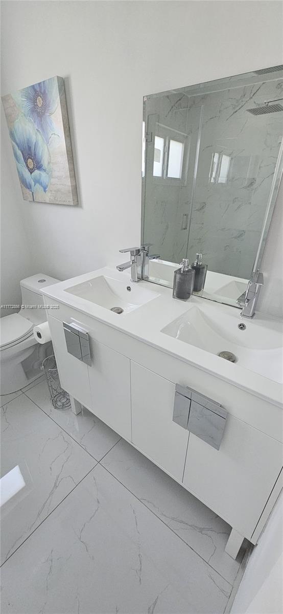 1531 SW 126th Pl, Miami, FL 33184 - bathroom with double vanity, marble finish floor, toilet, a sink, and a marble finish shower