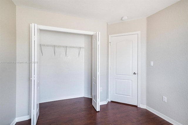 16122 SW 104th Ter, Miami, FL 33196 - unfurnished bedroom with a closet, baseboards, and dark wood-style flooring