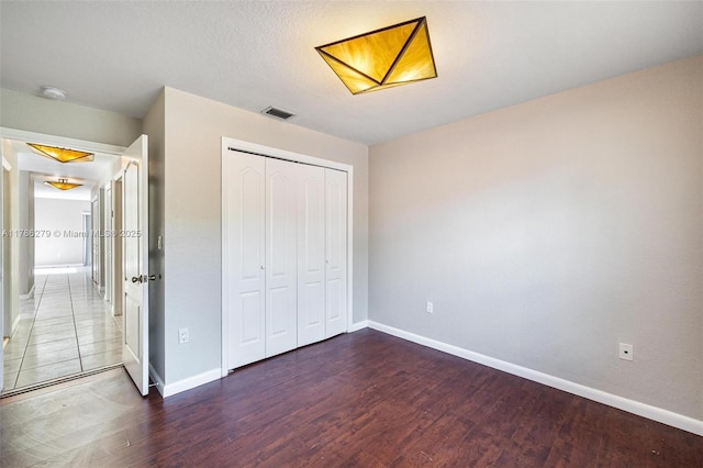16122 SW 104th Ter, Miami, FL 33196 - unfurnished bedroom featuring baseboards, wood finished floors, visible vents, and a closet