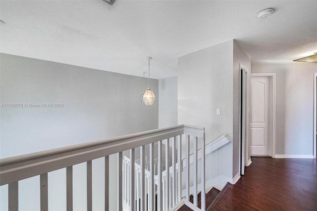 16122 SW 104th Ter, Miami, FL 33196 - corridor with baseboards, wood finished floors, a textured ceiling, and an upstairs landing