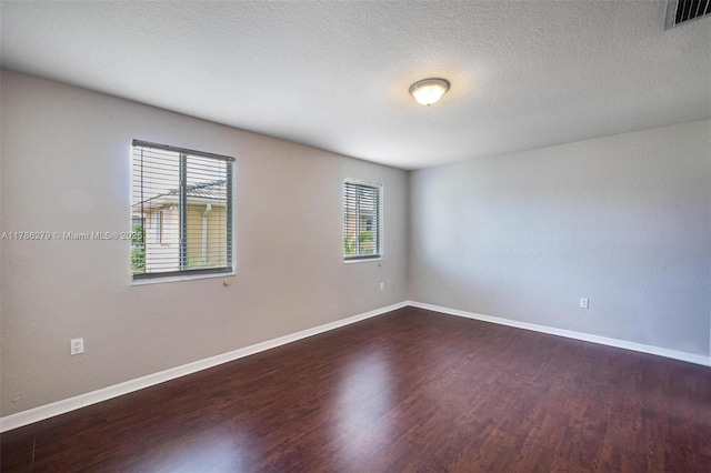 16122 SW 104th Ter, Miami, FL 33196 - spare room with a textured ceiling, dark wood finished floors, visible vents, and baseboards