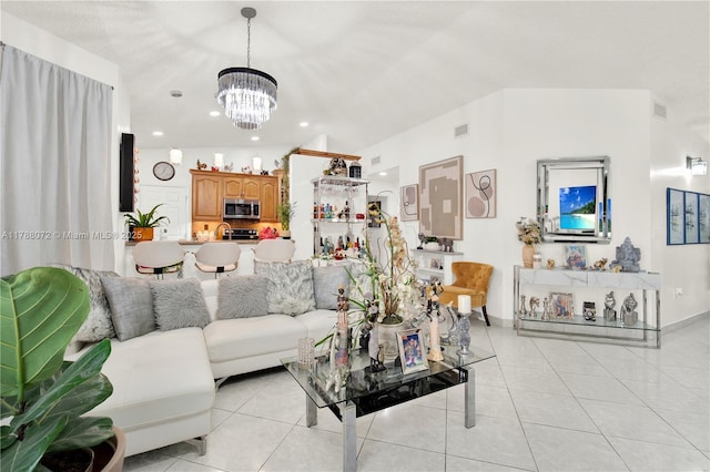 living area with baseboards, a notable chandelier, light tile patterned flooring, and visible vents