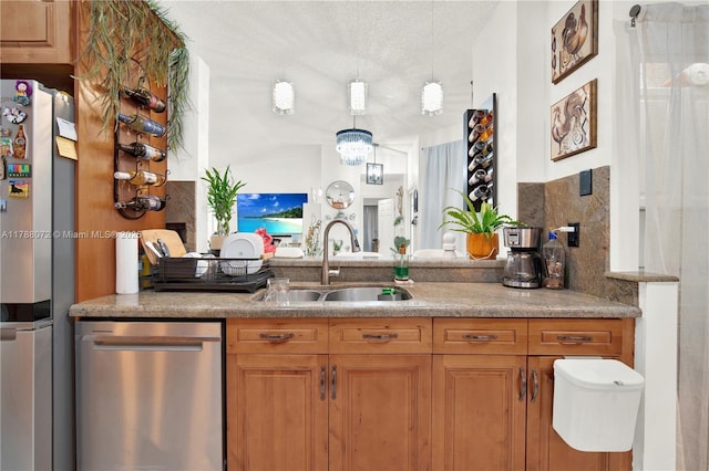 bar featuring stainless steel appliances, a textured ceiling, and a sink