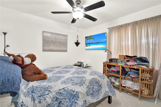 bedroom featuring tile patterned flooring, a textured ceiling, and ceiling fan