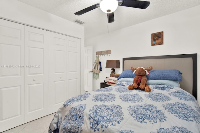 tiled bedroom featuring a ceiling fan, visible vents, a textured ceiling, and a closet
