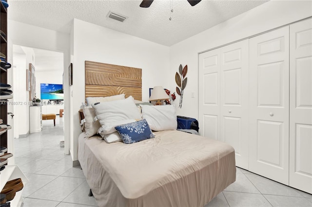 bedroom with visible vents, a textured ceiling, a closet, and light tile patterned floors