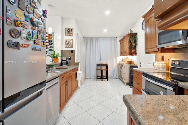kitchen featuring a sink, light tile patterned floors, pendant lighting, appliances with stainless steel finishes, and recessed lighting