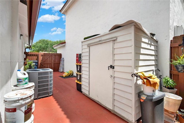 view of shed with central AC and fence
