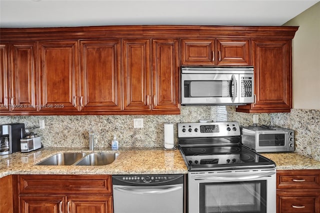 kitchen with a toaster, a sink, light stone countertops, tasteful backsplash, and appliances with stainless steel finishes
