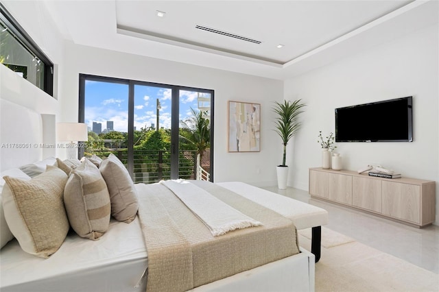bedroom featuring light tile patterned floors, access to outside, and a raised ceiling