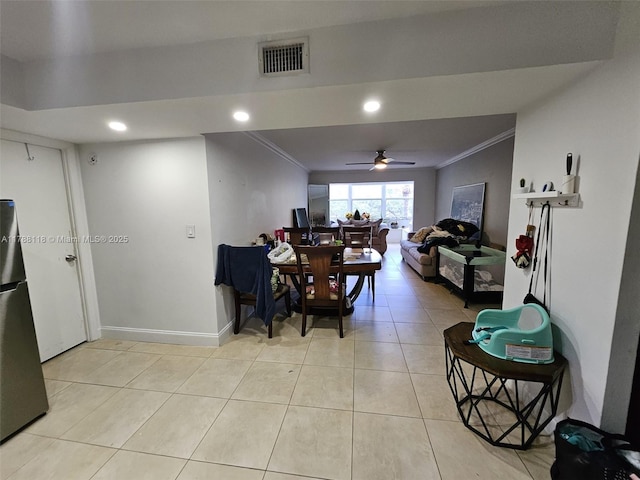 dining area featuring a ceiling fan, light tile patterned flooring, baseboards, ornamental molding, and visible vents