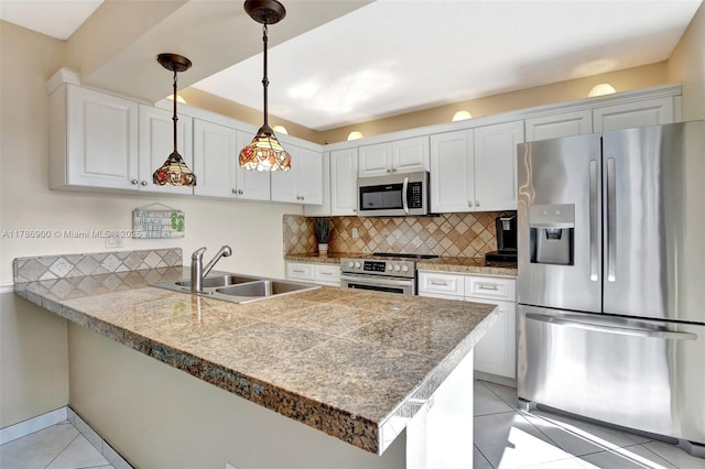 11914 SW 12th Ct, Davie, FL 33325 - kitchen featuring appliances with stainless steel finishes, tile countertops, a sink, a peninsula, and light tile patterned flooring