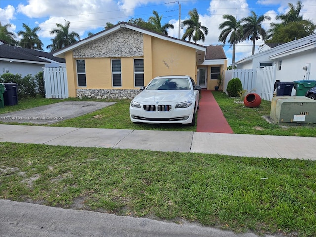13061 SW 56th Ter, Miami, FL 33183 - view of front of property with stucco siding, fence, a front yard, and stone siding