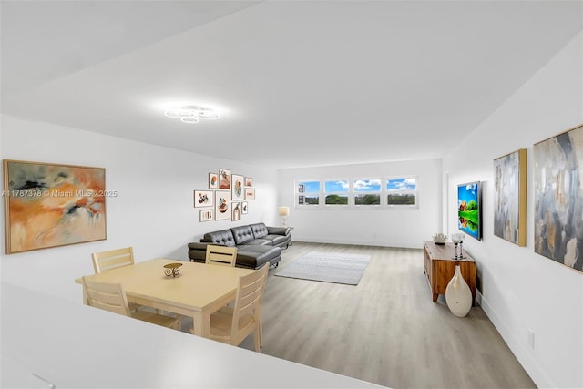 dining area with baseboards and wood finished floors