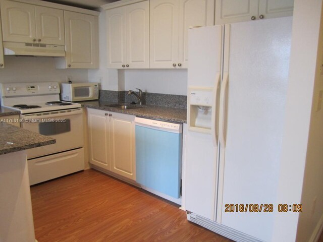 3500 Coral Way Unit 903, Miami, FL 33145 - kitchen featuring white cabinets, light wood-style flooring, a sink, white appliances, and under cabinet range hood