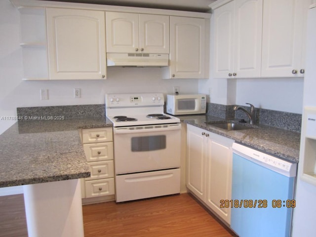 3500 Coral Way Unit 903, Miami, FL 33145 - kitchen with white cabinets, light wood finished floors, a sink, white appliances, and under cabinet range hood