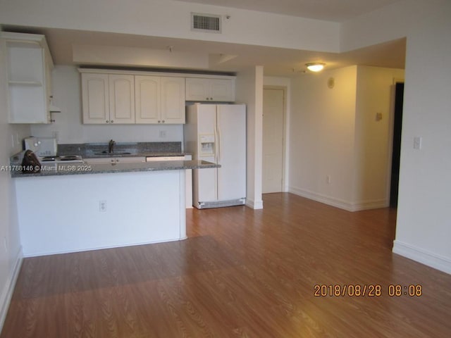 3500 Coral Way Unit 903, Miami, FL 33145 - kitchen with stove, visible vents, a sink, a peninsula, and white fridge with ice dispenser