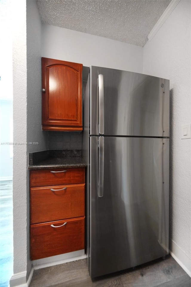 621 Hudson Rd, West Palm Beach, FL 33405 - kitchen with brown cabinets, dark wood-type flooring, freestanding refrigerator, baseboards, and a textured ceiling