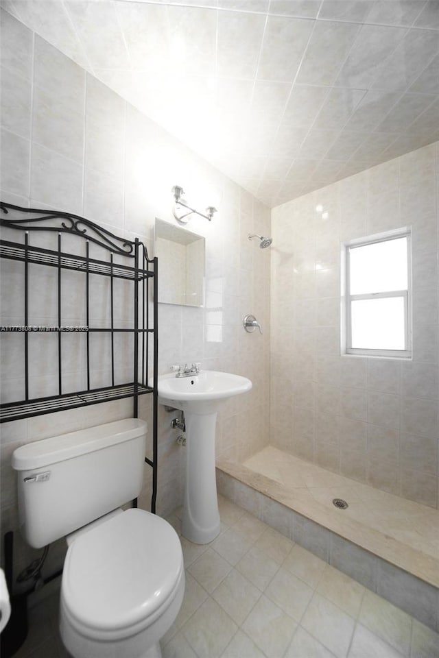 621 Hudson Rd, West Palm Beach, FL 33405 - bathroom with tile walls, tile patterned flooring, a shower stall, and toilet