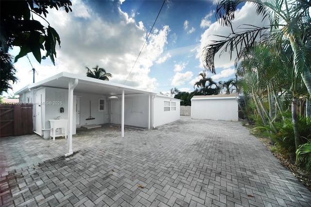 621 Hudson Rd, West Palm Beach, FL 33405 - rear view of house featuring fence, a gate, a carport, and stucco siding