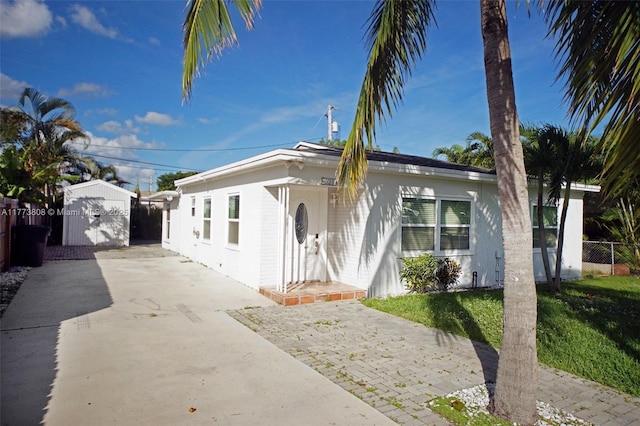 621 Hudson Rd, West Palm Beach, FL 33405 - bungalow-style house with an outbuilding, driveway, fence, a shed, and a front yard