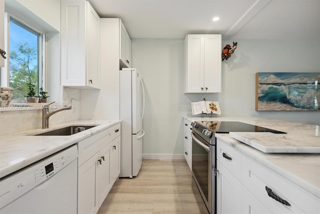 kitchen with light stone counters, a sink, white appliances, light wood-type flooring, and recessed lighting