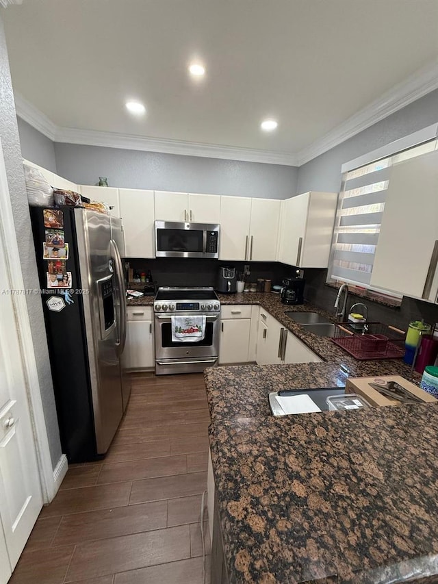 7353 NW 174th Ter Unit 107, Hialeah, FL 33015 - kitchen with appliances with stainless steel finishes, crown molding, white cabinetry, wood tiled floors, and recessed lighting